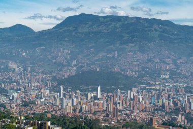 Medellin, Antioquia, Kolombiya. 18 Temmuz 2020: Dağları ve mavi gökyüzüyle Medellin şehrinin panoramik ve kentsel manzarası.