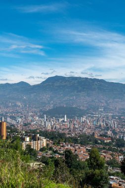 Medellin, Antioquia, Kolombiya. 18 Temmuz 2020: Dağları ve mavi gökyüzüyle Medellin şehrinin panoramik ve kentsel manzarası.