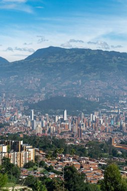 Medellin, Antioquia, Kolombiya. 18 Temmuz 2020: Dağları ve mavi gökyüzüyle Medellin şehrinin panoramik ve kentsel manzarası.