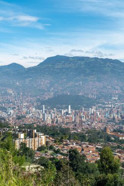 Medellin, Antioquia, Kolombiya. 18 Temmuz 2020: Dağları ve mavi gökyüzüyle Medellin şehrinin panoramik ve kentsel manzarası.
