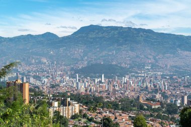 Medellin, Antioquia, Kolombiya. 18 Temmuz 2020: Dağları ve mavi gökyüzüyle Medellin şehrinin panoramik ve kentsel manzarası.