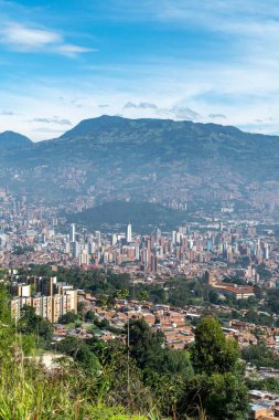 Medellin, Antioquia, Kolombiya. 18 Temmuz 2020: Dağları ve mavi gökyüzüyle Medellin şehrinin panoramik ve kentsel manzarası.