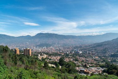 Medellin, Antioquia, Kolombiya. 18 Temmuz 2020: Dağları ve mavi gökyüzüyle Medellin şehrinin panoramik ve kentsel manzarası.