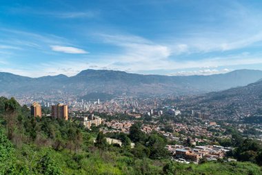 Medellin, Antioquia, Kolombiya. 18 Temmuz 2020: Dağları ve mavi gökyüzüyle Medellin şehrinin panoramik ve kentsel manzarası.