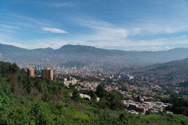 Medellin, Antioquia, Kolombiya. 18 Temmuz 2020: Dağları ve mavi gökyüzüyle Medellin şehrinin panoramik ve kentsel manzarası.