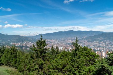 Medellin, Antioquia, Kolombiya. 18 Temmuz 2020: Dağları ve mavi gökyüzüyle Medellin şehrinin panoramik ve kentsel manzarası