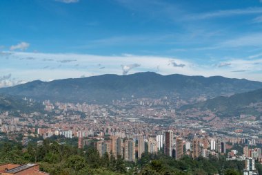 Medellin, Antioquia, Kolombiya. 18 Temmuz 2020: Dağları ve mavi gökyüzüyle Medellin şehrinin panoramik ve kentsel manzarası