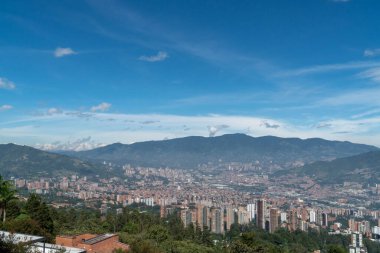 Medellin, Antioquia, Kolombiya. 18 Temmuz 2020: Dağları ve mavi gökyüzüyle Medellin şehrinin panoramik ve kentsel manzarası