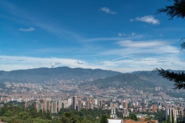 Medellin, Antioquia, Kolombiya. 18 Temmuz 2020: Dağları ve mavi gökyüzüyle Medellin şehrinin panoramik ve kentsel manzarası