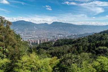 Medellin, Antioquia, Kolombiya. 18 Temmuz 2020: Dağları ve mavi gökyüzüyle Medellin şehrinin panoramik ve kentsel manzarası