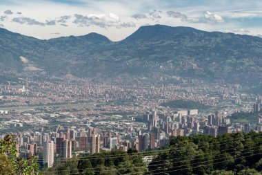 Medellin, Antioquia, Kolombiya. 18 Temmuz 2020: Dağları ve mavi gökyüzüyle Medellin şehrinin panoramik ve kentsel manzarası