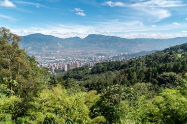 Medellin, Antioquia, Kolombiya. 18 Temmuz 2020: Dağları ve mavi gökyüzüyle Medellin şehrinin panoramik ve kentsel manzarası