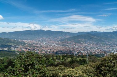 Medellin, Antioquia, Kolombiya. 18 Temmuz 2020: Dağları ve mavi gökyüzüyle Medellin şehrinin panoramik ve kentsel manzarası
