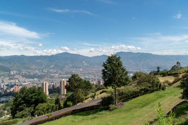 Medellin, Antioquia, Kolombiya. 18 Temmuz 2020: Dağları ve mavi gökyüzüyle Medellin şehrinin panoramik ve kentsel manzarası