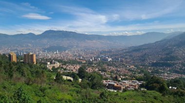 Medellin, Antioquia, Kolombiya. 18 Temmuz 2020: Dağları ve mavi gökyüzüyle Medellin şehrinin panoramik ve kentsel manzarası.