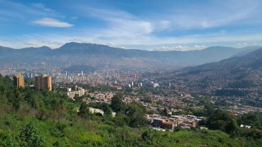 Medellin, Antioquia, Kolombiya. 18 Temmuz 2020: Dağları ve mavi gökyüzüyle Medellin şehrinin panoramik ve kentsel manzarası.