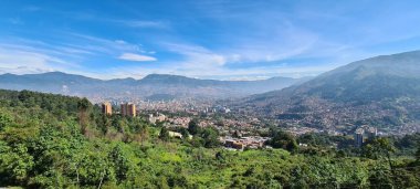 Medellin, Antioquia, Kolombiya. 18 Temmuz 2020: Dağları ve mavi gökyüzüyle Medellin şehrinin panoramik ve kentsel manzarası.