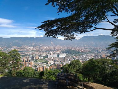 Medellin, Antioquia, Kolombiya. 18 Temmuz 2020: Dağları ve mavi gökyüzüyle Medellin şehrinin panoramik ve kentsel manzarası.