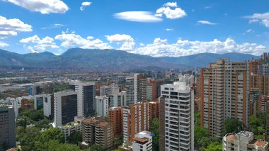 Medellin, Antioquia, Kolombiya. 3 Mayıs 2023: Şehirdeki binalar ve mavi gökyüzüyle manzara.