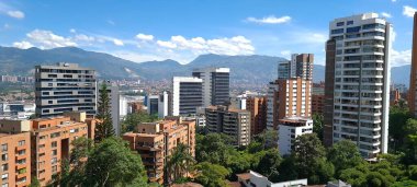 Medellin, Antioquia, Kolombiya. 3 Mayıs 2023: Şehirdeki binalar ve mavi gökyüzüyle manzara.