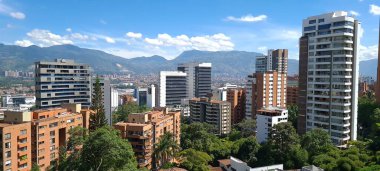 Medellin, Antioquia, Kolombiya. 3 Mayıs 2023: Şehirdeki binalar ve mavi gökyüzüyle manzara.