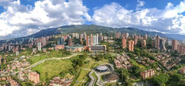 Medellin, Antioquia, Kolombiya. 2020 Ağustos 'unda Medellin, Poblado' daki UVA Ilusin parkının panoramik manzarası. Mavi gökyüzü ve dağlar.