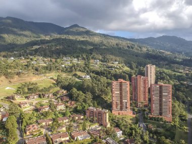 Medellin, Antioquia, Kolombiya. 2020 Ağustos 'unda Medellin, Poblado' daki UVA Ilusin parkının panoramik manzarası. Mavi gökyüzü ve dağlar.