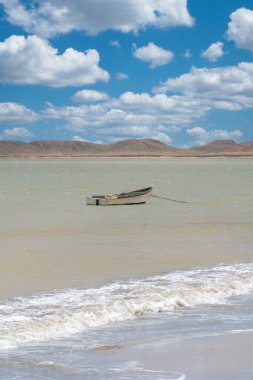 boat in the sea and landscape with blue sky on the beach. Cabo de la Vela, Guajira, Colombia. clipart