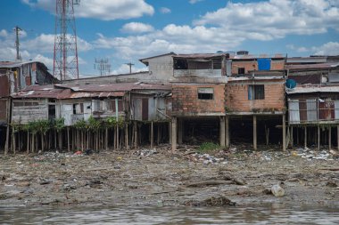 Choco, Quibdo, Colombia. March 4, 2020: Houses in the shore of the Atrato River with blue sky.  clipart
