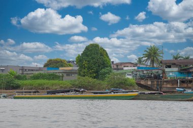 Choco, Quibdo, Colombia. March 4, 2020: Houses in the shore of the Atrato River with blue sky.  clipart