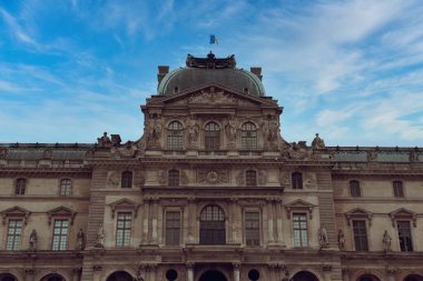 Paris, Fransa. 24 Nisan 2022 Louvre Müzesi ve mavi gökyüzü ile saray.