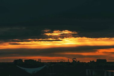 Almanya 'nın sanayi bölgesinde makinelerin siluetleriyle gün batımı.