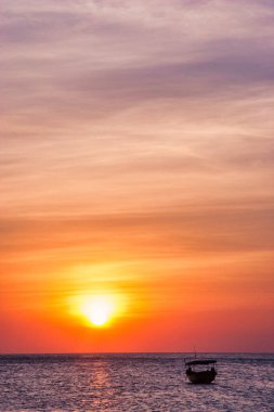 Sahildeki manzara, renkli günbatımı ve deniz kıyısındaki insanlar..