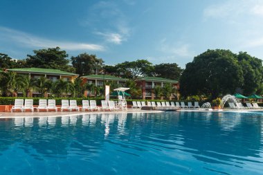 Plajda mavi gökyüzü ve dinlenmek için sandalyeli şemsiyeler olan bir portre. Panama. 