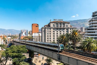 Medellin, Antioquia, Kolombiya. 17 Ocak 2024: Mavi gökyüzü ile Nutibara Oteli ve Medellin metro rayları.