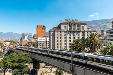 Medellin, Antioquia, Kolombiya. 17 Ocak 2024: Mavi gökyüzü ile Nutibara Oteli ve Medellin metro rayları.
