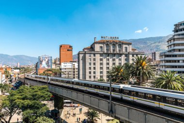 Medellin, Antioquia, Kolombiya. 17 Ocak 2024: Mavi gökyüzü ile Nutibara Oteli ve Medellin metro rayları.