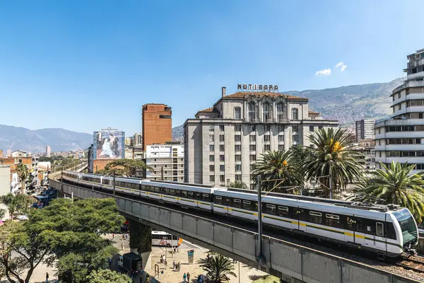 Medellin, Antioquia, Kolombiya. 17 Ocak 2024: Mavi gökyüzü ile Nutibara Oteli ve Medellin metro rayları.