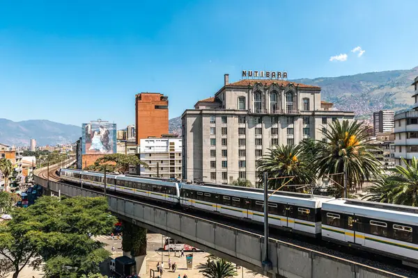 Medellin, Antioquia, Kolombiya. 17 Ocak 2024: Mavi gökyüzü ile Nutibara Oteli ve Medellin metro rayları.