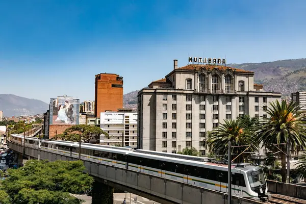 stock image Medellin, Antioquia, Colombia. January 17, 2024: View of the Nutibara hotel and the Medellin metro rails with blue sky.