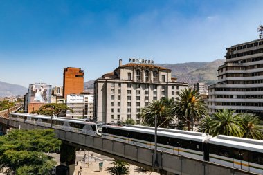 Medellin, Antioquia, Kolombiya. 17 Ocak 2024: Mavi gökyüzü ile Nutibara Oteli ve Medellin metro rayları.