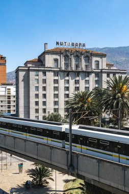 Medellin, Antioquia, Colombia. January 17, 2024: View of the Nutibara hotel and the Medellin metro rails with blue sky. clipart