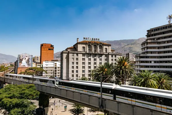Medellin, Antioquia, Kolombiya. 17 Ocak 2024: Mavi gökyüzü ile Nutibara Oteli ve Medellin metro rayları.