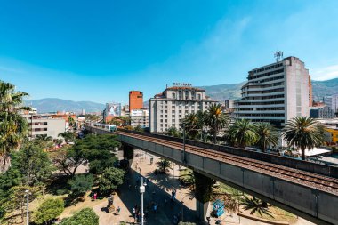 Medellin, Antioquia, Kolombiya. 17 Ocak 2024: Mavi gökyüzü ile Nutibara Oteli ve Medellin metro rayları.