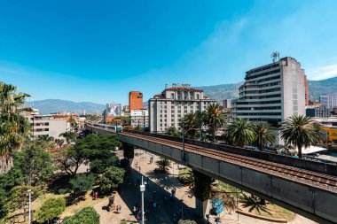 Medellin, Antioquia, Kolombiya. 17 Ocak 2024: Mavi gökyüzü ile Nutibara Oteli ve Medellin metro rayları.