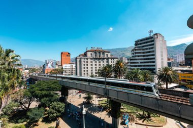 Medellin, Antioquia, Kolombiya. 17 Ocak 2024: Mavi gökyüzü ile Nutibara Oteli ve Medellin metro rayları.