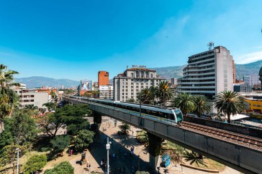 Medellin, Antioquia, Kolombiya. 17 Ocak 2024: Mavi gökyüzü ile Nutibara Oteli ve Medellin metro rayları.