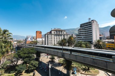 Medellin, Antioquia, Kolombiya. 17 Ocak 2024: Mavi gökyüzü ile Nutibara Oteli ve Medellin metro rayları.