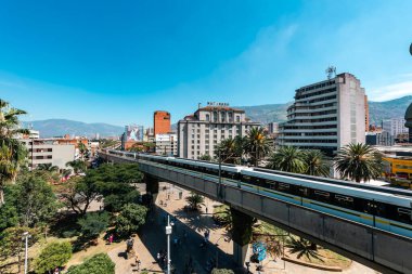 Medellin, Antioquia, Kolombiya. 17 Ocak 2024: Mavi gökyüzü ile Nutibara Oteli ve Medellin metro rayları.