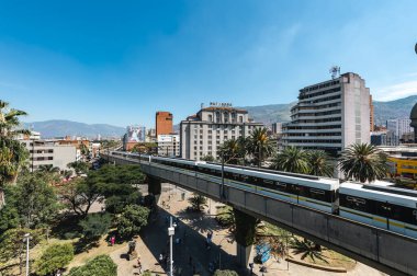 Medellin, Antioquia, Kolombiya. 17 Ocak 2024: Mavi gökyüzü ile Nutibara Oteli ve Medellin metro rayları.